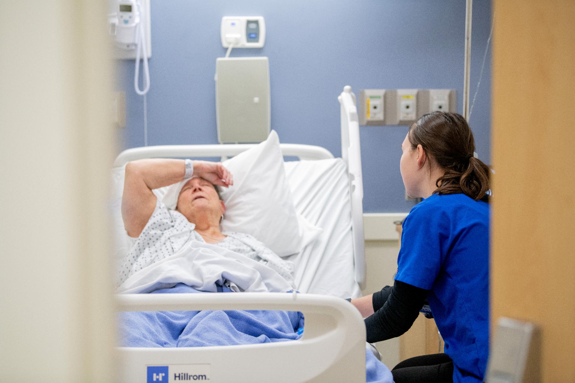 students in blue scrubs observes patient